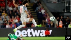 Crystal Palace's goalkeeper Wayne Hennessey, left, makes a save in front of Liverpool's Mohamed Salah during the English Premier League soccer match between Crystal Palace and Liverpool at Selhurst Park stadium in London, Monday, Aug. 20, 2018. 