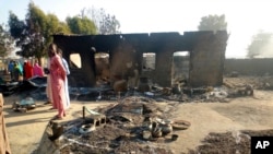 FILE - People return to the site of an attack in Maiduguri, Nigeria, Thursday, Nov. 1, 2018, after dozens of attackers overpowered soldiers guarding the camp and fighting continued for about two hours. 