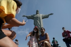 Turistas disfrutan de una visita a la estatua del Cristo Redentor, en el Cerro Corcovado, en Río de Janeiro, Brasil, el 15 de agosto de 2020, durante el día de reapertura de las atracciones turísticas de la ciudad en medio de la pandemia del Covid.