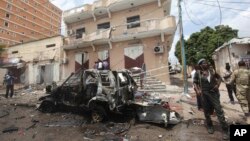 FILE - A Somali soldier stands on guard next to a destroyed car near a popular mall after a car bomb attack in Mogadishu, Somalia, July 30, 2017. The Somalia-based extremist group al-Shabab often carries out deadly bombings in Mogadishu. 