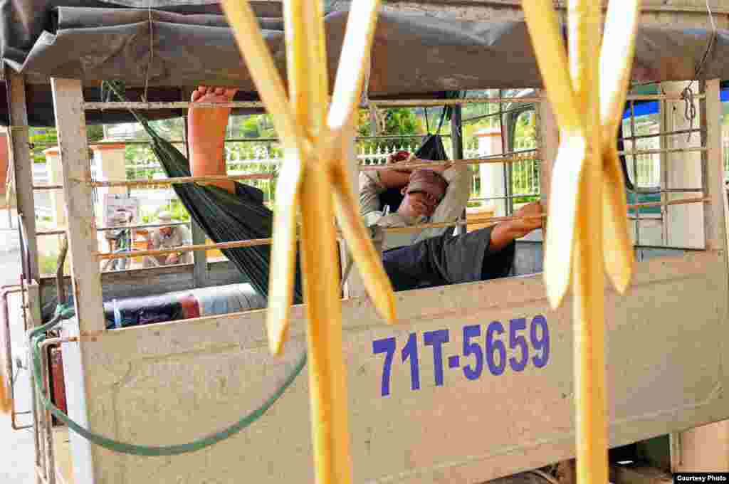 The driver takes a nap while waiting for guests to visit the Vinh Trang pagoda in My Tho, the capital city of Tien Giang province, Vietnam. (Photo by Hillary Tran/Vietnam/VOA reader)