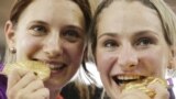 Germany's Kristina Vogel, right and teammate Miriam Welte, bite their gold medals after winning the women's team sprint track cycling event at the 2012 Summer Olympics, Aug. 2, 2012, in London. 