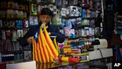 A seller organizes esteladas or independence flags to sell in a shop in Barcelona, Spain, Oct. 11, 2017.