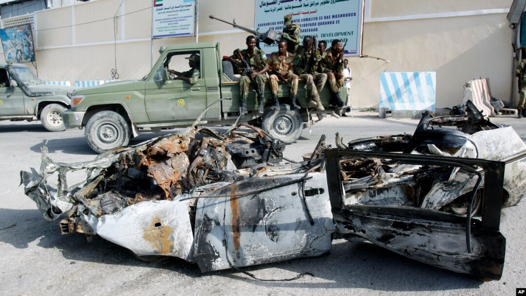 Tentara Somalia mengamati puing-puing mobil yang meledak di komplek istana Presiden di Mogadishu (8/7). 