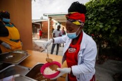Volunteers and teachers serve food at a school feeding program during a nationwide lockdown aimed at limiting the spread of COVID-19 in Cape Town, South Africa, May 7, 2020.