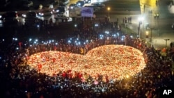 People create a heart shaped with candles as a tribute to slain mayor of Gdansk Pawel Adamowicz in Gdansk, Poland, Jan. 16, 2019.