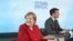 Germany's Chancellor Angela Merkel and France's President Emmanuel Macron sit at the table at the start of the G-7 summit in Carbis Bay, Cornwall, on June 11, 2021.
