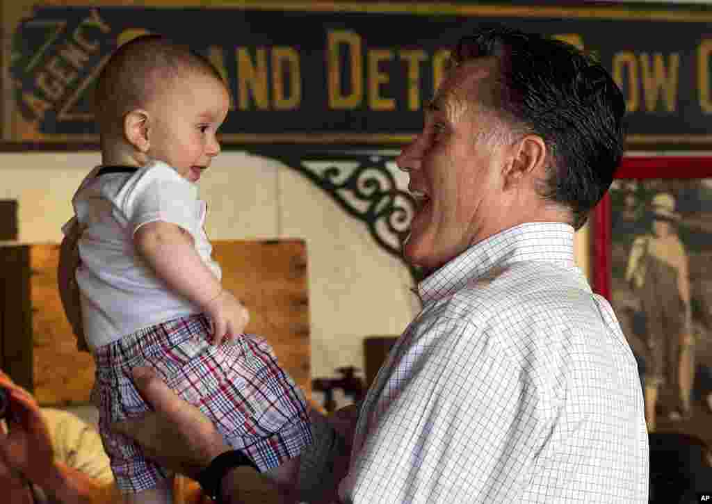 Republican presidential candidate former Massachusetts Gov. Mitt Romney lifts 8-month-old Gavin Woodford, of Rockford, Illinois, during a campaign stop, March 18, 2012. (AP)