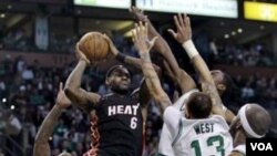 LeBron James (6) dihadang oleh para pemain Boston Celtics ketika berusaha memasukan bola. Heat mengalahkan Celtics 98-90 di babak perpanjangan waktu.