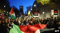 Demonstranti mašu zastavama i transparentima dok učestvuju u 'Nacionalnom maršu za Palestinu' u centru Londona 25. novembra 2023., pozivajući na prekid vatre u sukobu između Izraela i Hamasa.