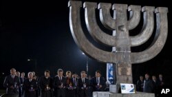 Left to right: Ukraine's Parliament speaker Andriy Parubiy, German President Joachim Gauck, Hungarian President Janos Ader, Ukraine's President Petro Poroshenko and his wife Marina, President of the European Council Donald Tusk and Ukrainian Prime Minister, Volodymyr Groysman light candles at a monument in Babi Yar ravine where Nazi troops machine-gunned tens of thousands of Jews during WWII, in Kyiv, Ukraine, Sept. 29, 2016. 