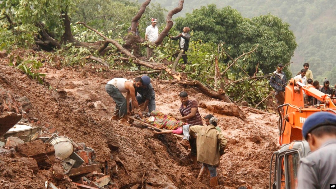 Rescue workers carry the body of a victim at the site of a landslide in Malin village, in the western Indian state of Maharashtra, July 30, 2014. 