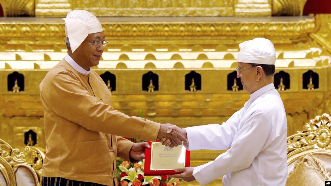 Presiden Htin Kyaw (kiri) menerima tanda kepresidenan dari mantan Presiden Thein Sein, dalam serah terima jabatan Presiden Myanmar di Naypyitaw (30/3).