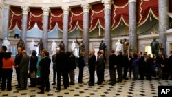 FILE - Members of Congress line up to file onto the House floor for a vote, on Capitol Hill in Washington.