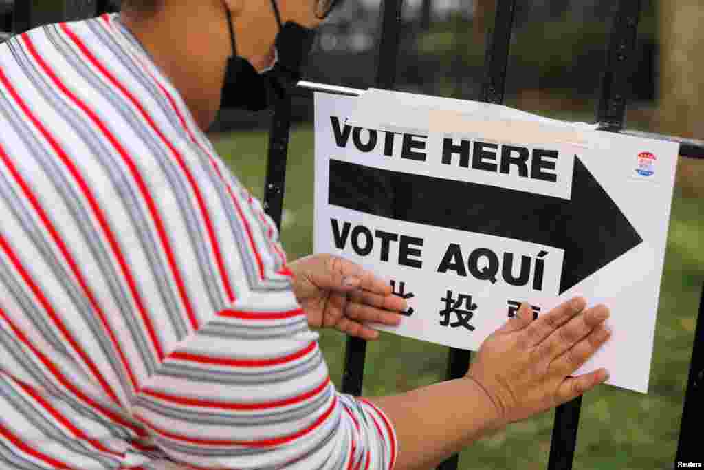 Un trabajador electoral coloca carteles fuera de un centro de votaci&#243;n en el Centro Comunitario James Weldon Johnson en Harlem, en la ciudad de Nueva York, Nueva York, 3 de noviembre de 2020.