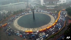 Kemacetan di tengah hujan di Bundaran Hotel Indonesia, Jakarta Pusat.