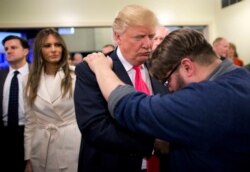 FILE - In this Jan. 31, 2016, photo, Pastor Joshua Nink, right, prays for then-presidential candidate Donald Trump, at First Christian Church in Council Bluffs, Iowa. Trump launched a coalition of evangelicals early in his 2020 presidential campaign.
