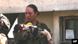 This undated photo provided by US Department of Defense Twitter page posted Aug. 20, 2021, shows Sgt. Nicole Gee holding a baby at Hamid Karzai International Airport in Kabul, Afghanistan. 