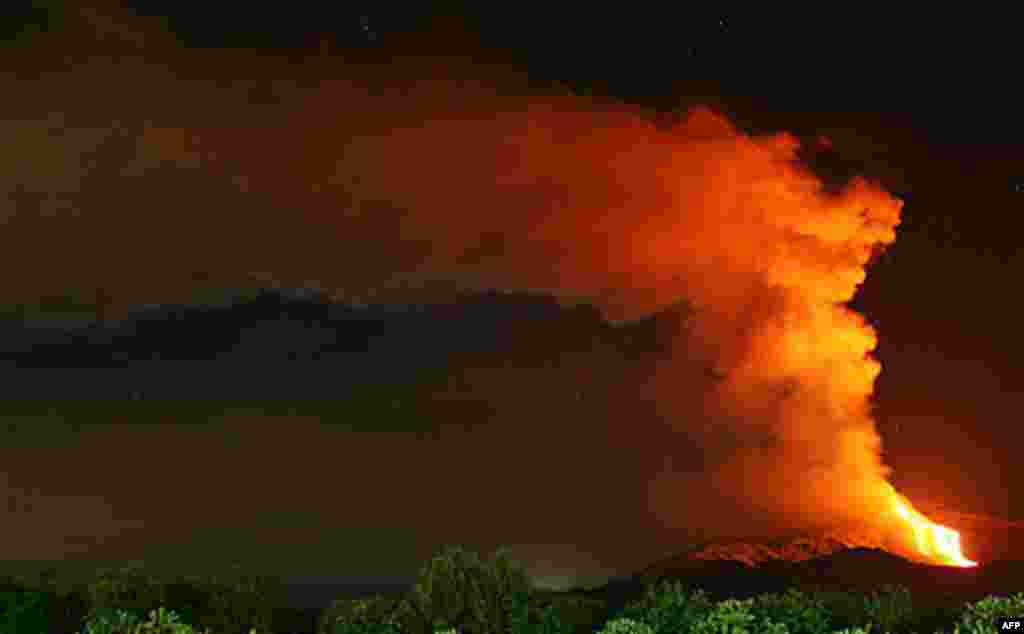 January 12: Lava overflows from the eastern rim of the erupting pit crater of Mount Etna, Sicily. Italy's Mount Etna has come back to life with a brief eruption that sent lava down its slopes and a cloud of ash into the sky. (Carmelo Imbesi/AP)