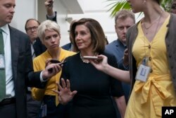Speaker of the House Nancy Pelosi, D-Calif., is surrounded by reporters as she arrives to meet with her caucus at the Capitol in Washington, after declaring she will launch a formal impeachment inquiry against President Donald Trump.