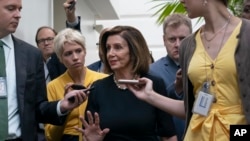 FILE - Speaker of the House Nancy Pelosi, D-Calif., is surrounded by reporters as she arrives to meet with her caucus at the Capitol in Washington, after declaring she will launch a formal impeachment inquiry against President Donald Trump.