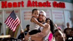 Durante las manifestaciones en Las Vegas, Ulysses Diaz sostiene a su hijo, Armani Hinton, mientras escucha los discursos sobre el veredicto del caso Zimmerman.