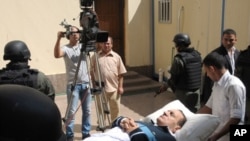 Former Egyptian president Hosni Mubarak lies on his bed while being taken to the courtroom for another session of his trial in Cairo, Egypt, September 7, 2011.