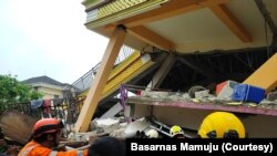 Tim penyelamat mencari korban yang tertimbun reruntuhan bangunan di Jalan Amakirang, Kota Mamuju, Sulawesi Barat. Jumat, 15 Januari 2021. (Foto: Basarnas Mamuju)