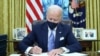 El presidente Joe Biden firma las primera órdenes ejecutivas de su mandato dentro de la Oficina Oval de la Casa Blanca en Washington D.C., el 20 de enero de 2021. 