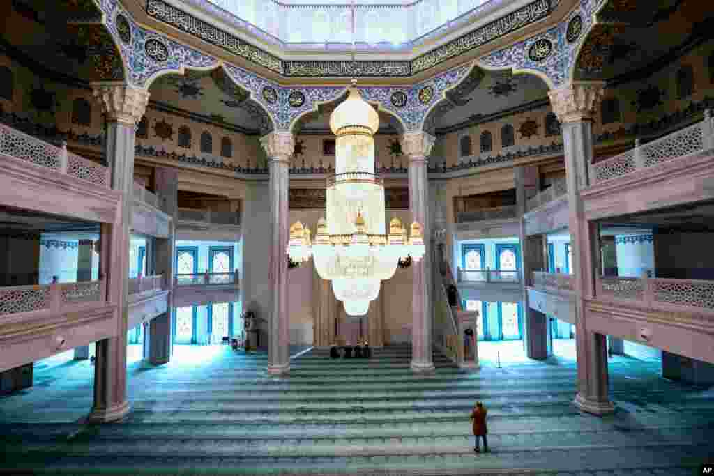 A believer and a group of mullahs attend a Friday prayer in the Moscow Cathedral Mosque in Moscow, Russia.