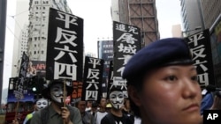 Protesters carry placards that read "Exonerate the June 4" during a rally in a Hong Kong down town street Sunday, May 29, 2011, ahead of the 22nd anniversary of the June 4th military crackdown on the pro-democracy movement in Beijing. (AP Photo/Vincent Yu