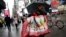 FILE - A woman walks through Times Square with holiday shopping bags, in New York, Dec. 2, 2015.