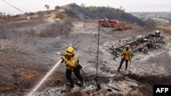 Firefighters extinguish hotspots as the Franklin Fire burns around Malibu, California, on Dec. 11, 2024. 