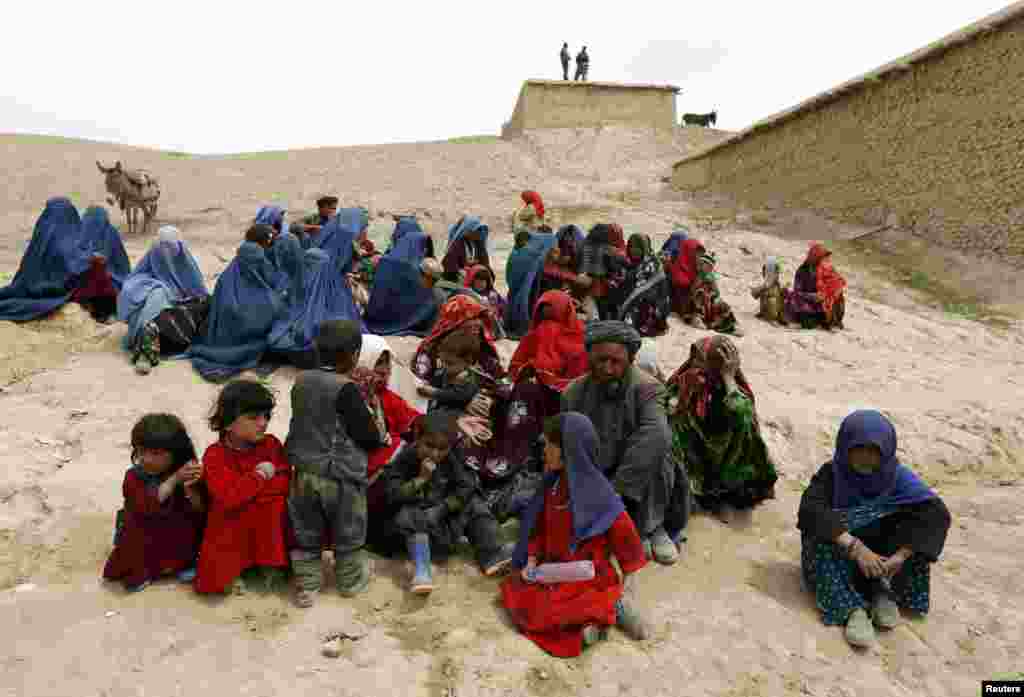 Para penyintas menanti bantuan dekat lokasi tanah longsor di distrik Argo, provinsi Badakhshan, Afghanistan (4/5). (Reuters/Mohammad Ismail)