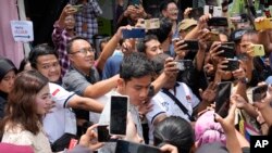 印尼副总统候选人、现任总统佐科·维多多(Joko Widodo)的儿子（中）在投票后被支持者簇拥。（美联社）