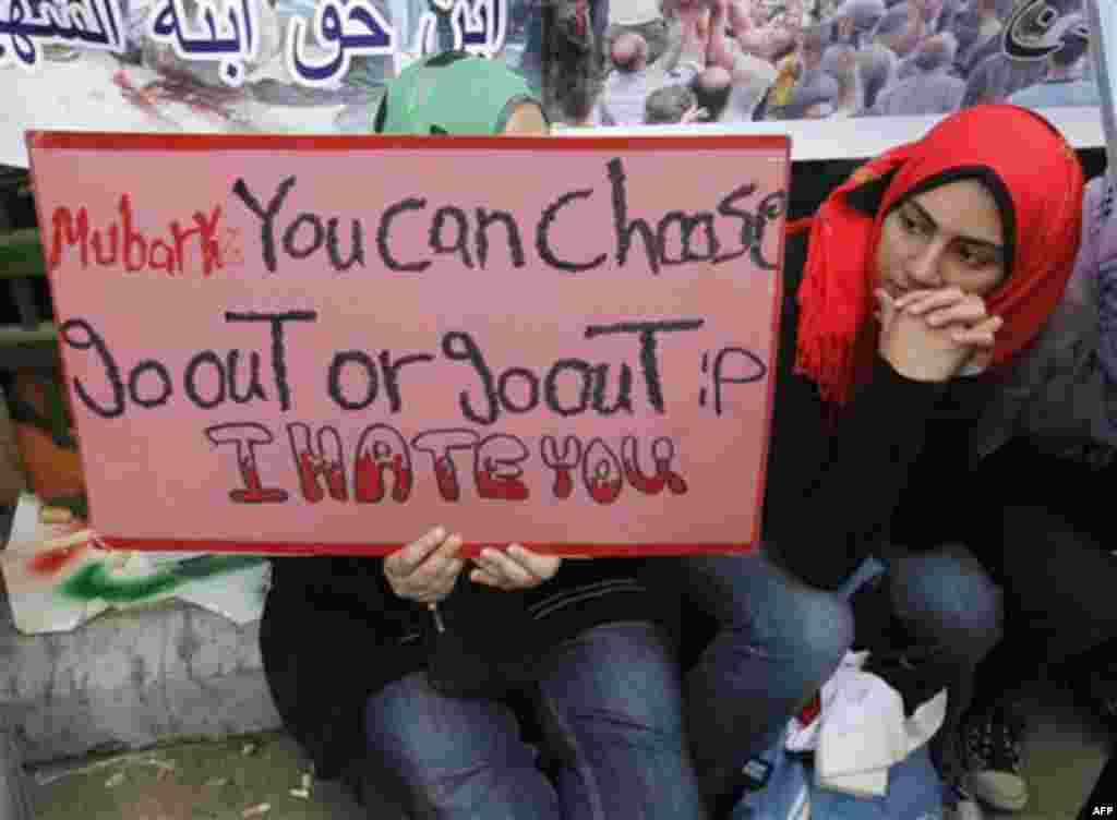 Anti-government protester holds anti-Mubarak placard as she sits at Tahrir square, in Cairo, Egypt, Friday, Feb. 11, 2011. Egypt exploded with joy, tears, and relief after pro-democracy protesters brought down President Hosni Mubarak with a momentous marc