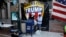 A postal worker collects mail from a mailbox inside the protest pen, as a handful of supporters of President Donald Trump continue to demonstrate, outside the Pennsylvania Convention Center in Philadelphia, Nov. 10, 2020. 