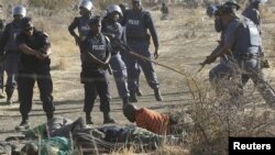 Polisi memberikan instruksi pada penambang yang terluka setelah ditembak polisi di Rustenberg, Afrika Selatan. (Foto: Reuters)