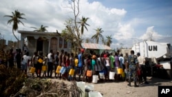 United Nations police from Bangladesh deliver drinking water to residents of Sous-Roche village, outside Les Cayes, Haiti, Oct. 11, 2016. 