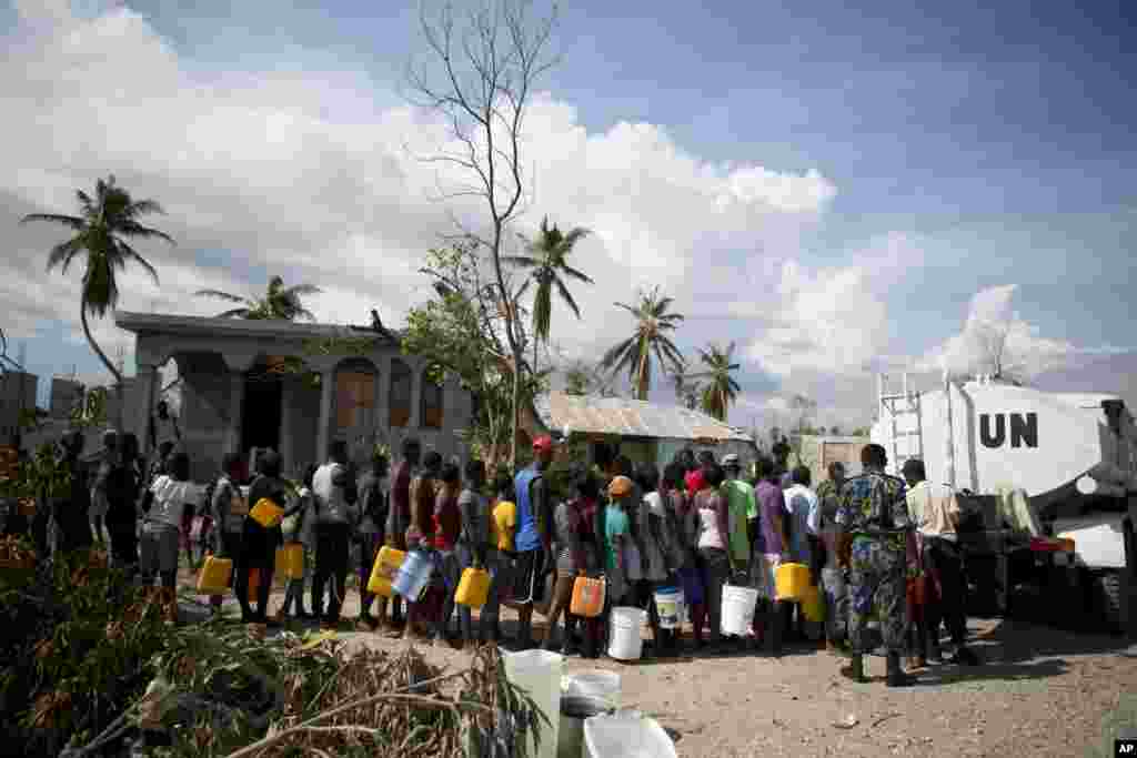 Polisi wa Umoja wa Mataifa kutoka Bangladesh wakitoa maji ya kunywa kwa wakazi wa kijiji cha Sous-Roche, karibu na mji wa Les Cayes, Haiti, Oct. 11, 2016.