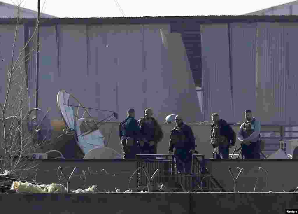 Foreign security forces inspect damage to a building at the site of a blast in Kabul, Nov. 18, 2014.