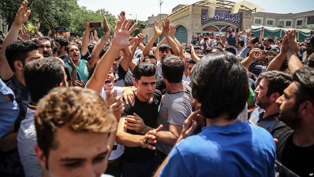 Sekelompok pengunjuk rasa meneriakkan slogan-slogan di pintu utama Grand Bazaar lama di Tehran, Iran, 25 Juni 2018 (foto: Kantor Berita Tenaga Kerja Iran via AP)