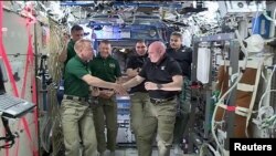 Astronot NASA Scott Kelly (Kanan) dan Tim Kopra dalam serah terima komando International Space Station kepada Kopra, 29 Feb 2016