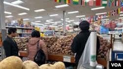 Consumidores seleccionan productos en un supermercado donde se registran incrementos en los precios de los alimentos en general. [Foto: Tomás Guevara, VOA]