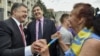 FILE - Ukrainian President Petro Poroshenko, left, and former Georgian President Mikheil Saakashvili, who now is governor of the Odessa oblast, are greeted by a local resident near the regional state administration in Odessa, May 30, 2015.