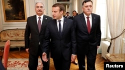 Le président français Emmanuel Macron avec le Premier ministre libyen Fayez al-Sarraj (à droite) et le général Khalifa Haftar (à gauche), près de Paris, France, le 25 juillet 2017.