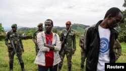 FILE - Two alleged M23 rebels spies, captured by the Wazalendo VDP (Volunteer for the Defense of the Fatherland) in the town of Goma, stand in one of the Wazalendo camps in Sake, Democratic Republic of Congo February 6, 2024