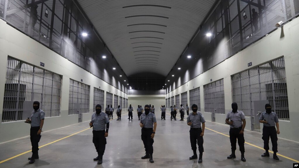Guardias civiles de la Dirección General de Prisiones apostados afuera de las celdas del Centro de Confinamiento contra el Terrorismo durante una gira de prensa en Tecoluca, El Salvador, el jueves 2 de febrero de 2023.