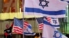 A man holds a U.S.-Israeli flag at a gathering to commemorate the October 7, 2023 attack in Israel that killed around 1,200 people, including more than 40 Americans, amid the ongoing Israel-Hamas conflict, in New York City, October 7, 2024. 