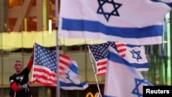 A man holds a U.S.-Israeli flag at a New York gathering on the first anniversary of the Oct. 7, 2023, attack in Israel that killed around 1,200 people, Oct. 7, 2024. 